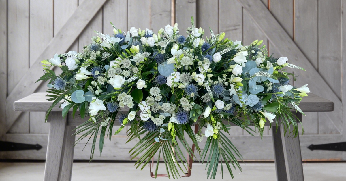 White and pale blue coffin spray by Beloved Flowers, funeral florist in Kent