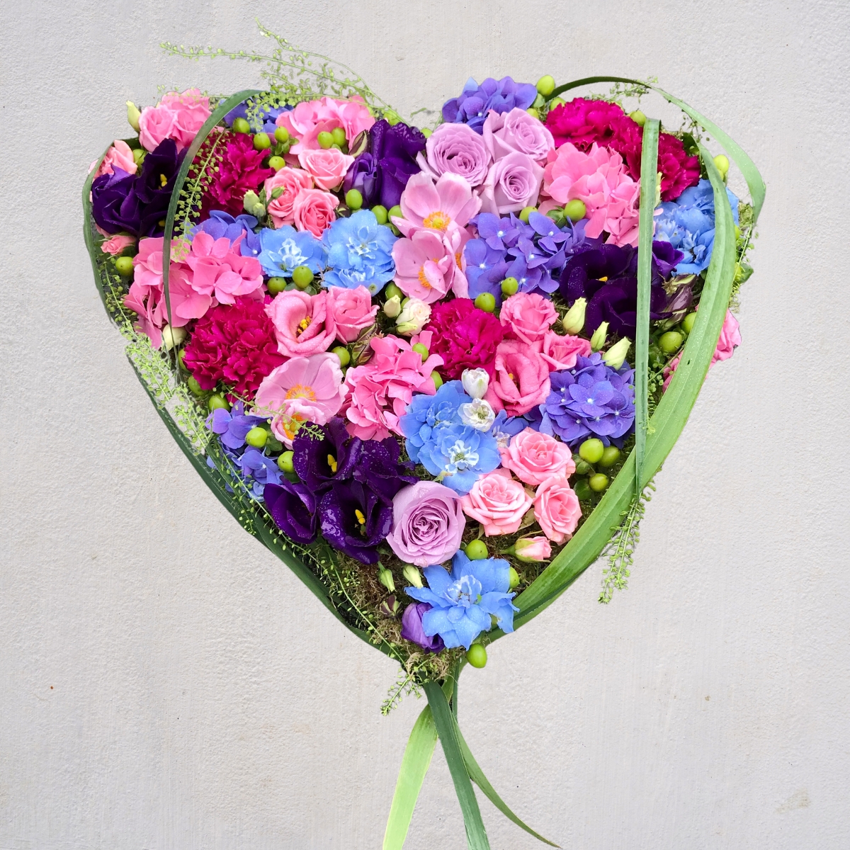 Blue, pink, lilac and purple spring heart funeral tribute by Beloved Flowers, Kent