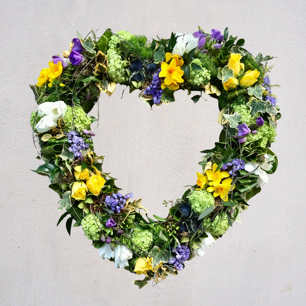 Blue, yellow and green spring open heart funeral tribute by Beloved Flowers, Kent