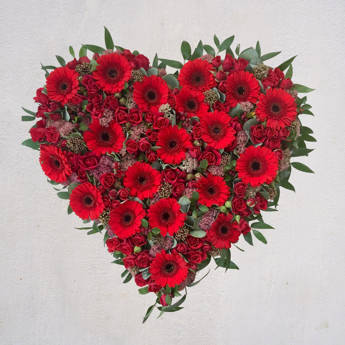 Red rose and gerbera heart-shaped funeral tribute by Beloved Flowers, Kent